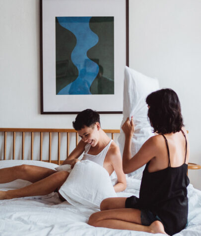 Two women having a pillow fight in hotel room