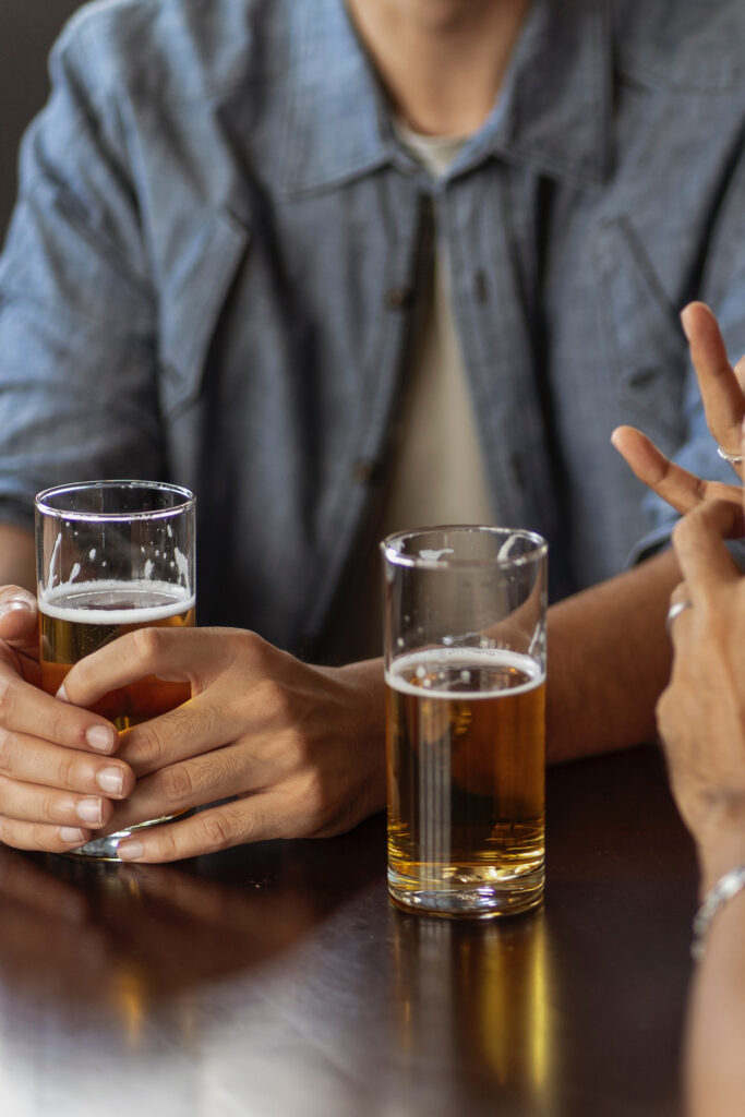 Undistinguishable people drinking beers at a pub